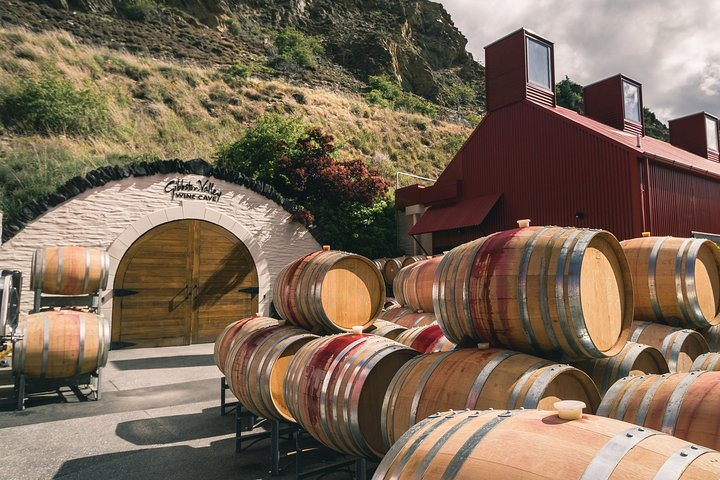 Immerse yourself in the heart of Gibbston Valley where wine barrels await your exploration and the stunning landscape complements a delightful journey through winemaking traditions.